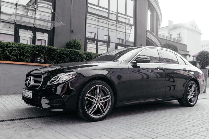 A black Mercedes-Benz executive saloon parked on a city street