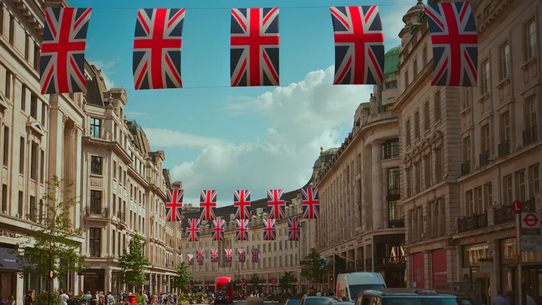 Union Jack flags strung across Regent Street with black cabs below